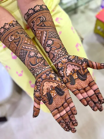 A non-figurative bridal design that uses bold lines and negative space to create a striking effect. The peacocks on the palms are a beautiful touch.