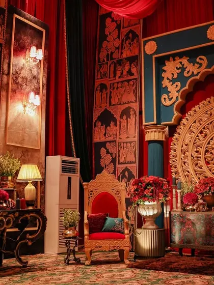 A regal photo corner inspired by the Mysore Palace, featuring a gilded throne chair and walls adorned with traditional Indian artwork. The deep red and teal color palette exudes royal opulence.
