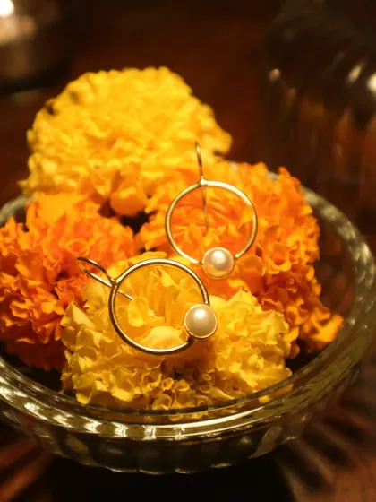 My pearl hoop earrings, shining bright amidst a bowl of fresh marigolds. A reminder that life always finds a way to expand and bloom.