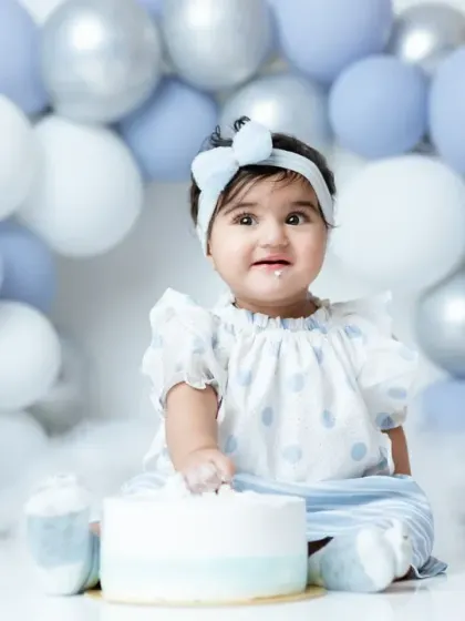 This little girl is having a wonderful time at her first birthday cakesmash, with a cute bow and a face full of frosting.