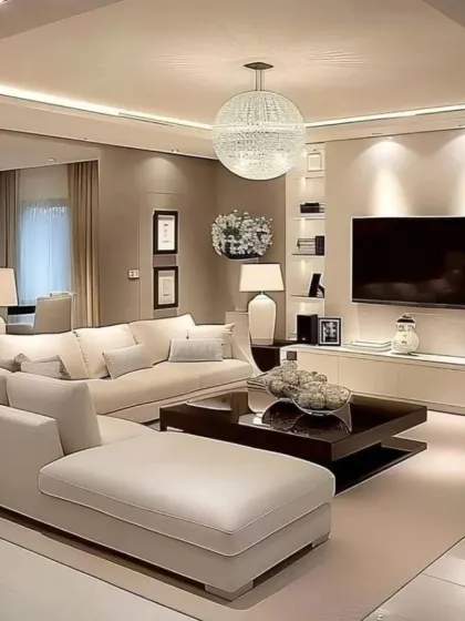 This living room is a study in warm neutrality, with beige sofas, a dark wood coffee table, and soft ambient lighting. We designed the space to feel cozy and inviting, with a large sectional providing ample room for relaxation.