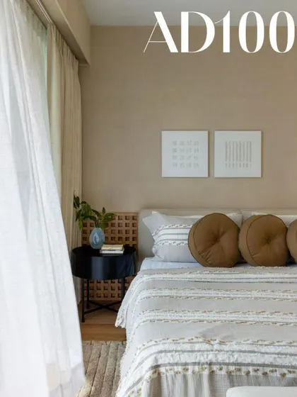 A bedroom detail from our AD100 feature. The combination of lime-washed walls, a simple headboard, and textured pillows creates a serene and sophisticated look.