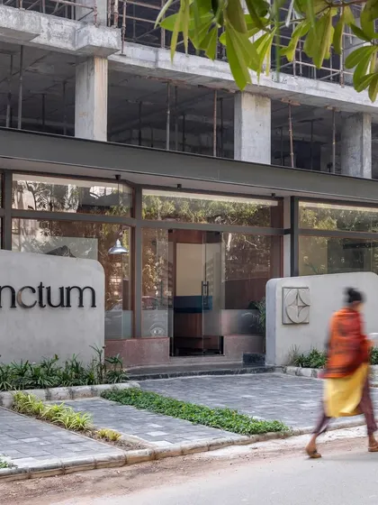 **Sanctum Site Office, Ahmedabad:** The site office serves as a quiet introduction to the Sanctum residential project. The clean concrete facade and simple branding offer a glimpse into the ethos of the main building: thoughtful, calm, and rooted in simplicity.