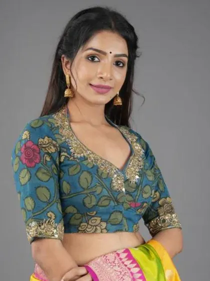 A closer look at our teal Kalamkari blouse with a collared V-neck and mirror work. The combination of hand-painting and embroidery is simply exquisite.