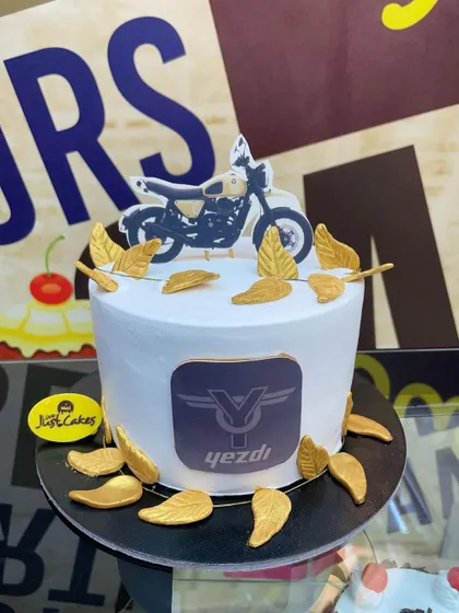 A 1.5kg cake for a Yezdi motorcycle fan, featuring the brand's logo and golden wing accents.