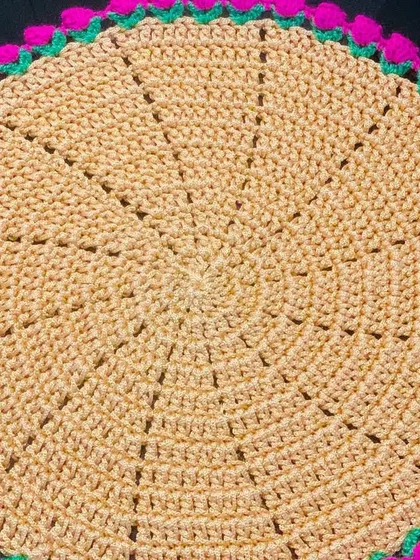 A close-up of the beige doily with a bright pink tulip border. The contrast between the neutral and the bright color is very eye-catching.