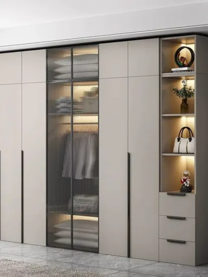 This wardrobe combines solid doors with a central fluted glass door, offering a glimpse of the contents while maintaining a clean look. The open shelving on the side is ideal for displaying decor.