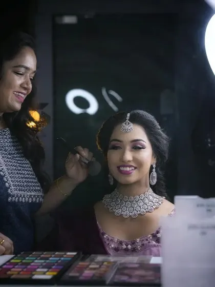 Here I am in my element, working with the lovely Nadeera Banu. This behind-the-scenes shot captures the process of creating a flawless reception look, complete with a diamond choker and a radiant smile.