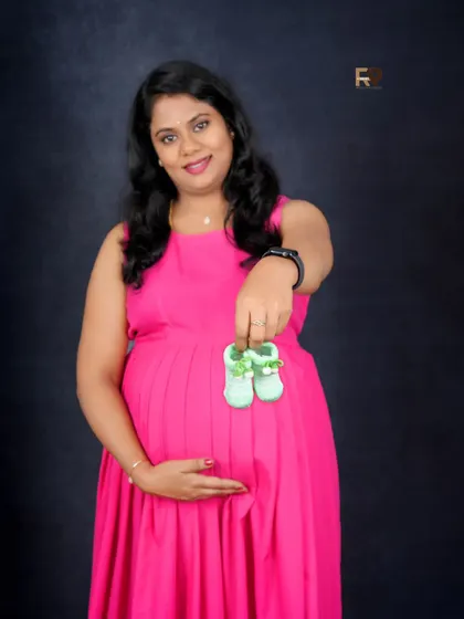 A solo portrait with a sweet prop. The mom-to-be holds up a tiny pair of baby shoes, a simple and touching way to celebrate the little one on the way.