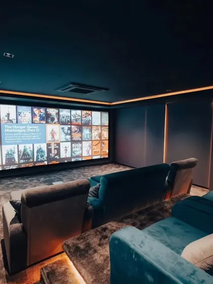 Another view of the finished theater, showing the clean lines of the wall panels and the impressive size of the projection screen.