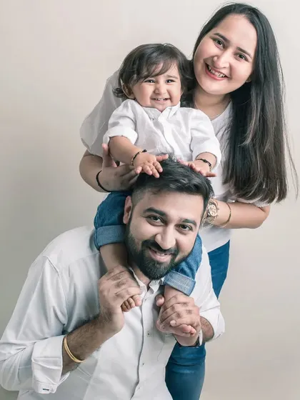 A playful moment on dad's shoulders. This family portrait is full of life and energy, showcasing the fun and loving dynamic between them.