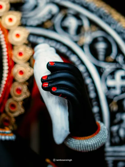 A detailed shot of the idol's hand holding a conch shell. Every element, from the painted nails to the delicate bracelet, is crafted with care, representing a small part of a much larger story of faith.