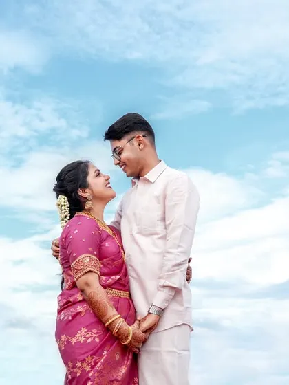 A classic romantic pose, capturing the couple's happy gaze against the sky.