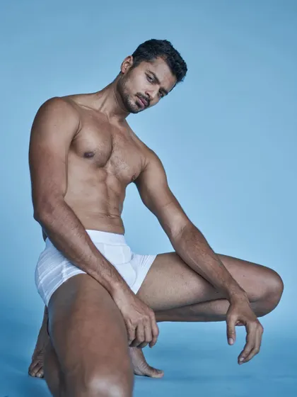 A dynamic pose from a fitness and underwear-themed studio shoot.