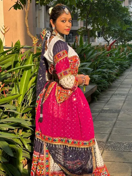 A view from the back, showing the tie-up detail of the blouse and the way the dupatta is draped.