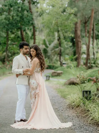A romantic portrait of the couple at their pool party. The soft, natural lighting and lush green background create a serene atmosphere, focusing on their gentle embrace.
