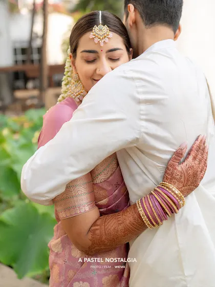 An intimate hug shows the practical side of a well-draped saree. The pleats and pallu remain secure, allowing the bride to fully embrace the special moments of her wedding day without any worry.