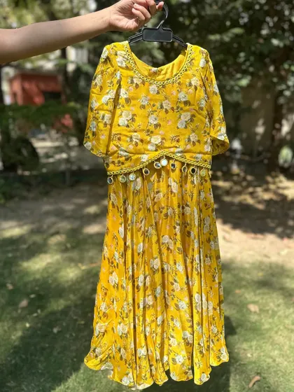 This yellow floral dress with a mirror-work belt is a perfect choice for a sunny day celebration. The lightweight fabric and cheerful print ensure your little one stays comfortable and stylish.