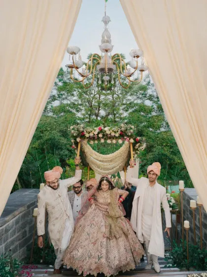 The bride's grand entrance under a 'phoolon ki chadar,' a moment of tradition and regal elegance.