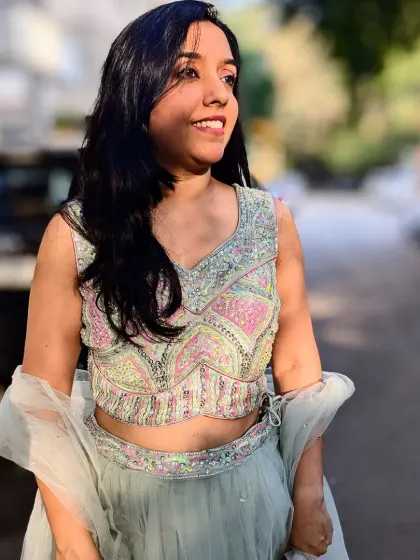 A close-up of the intricately embroidered blouse. The pastel pink and green sequins create a beautiful, shimmering effect that catches the light perfectly.