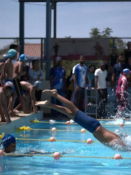 A perfect action shot of a competitive dive, highlighting the energy of our swimming competitions.