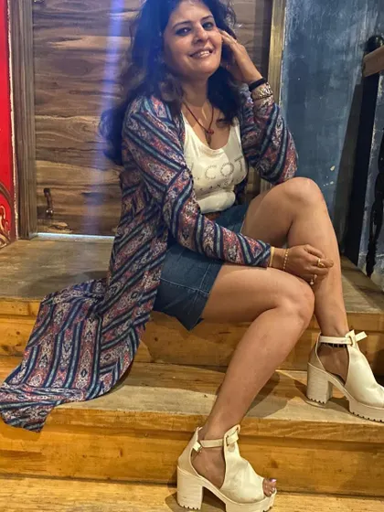 A seated pose in the same casual outfit, showing off the platform heels that add a bit of edge to the look.