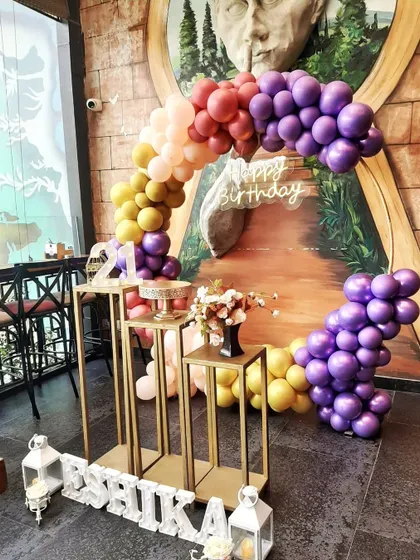 I love working with unique color combinations to make your birthday decor stand out. This beautiful balloon arch uses a sunset palette of purple, yellow, and orange for a truly memorable 21st birthday celebration at a local cafe.