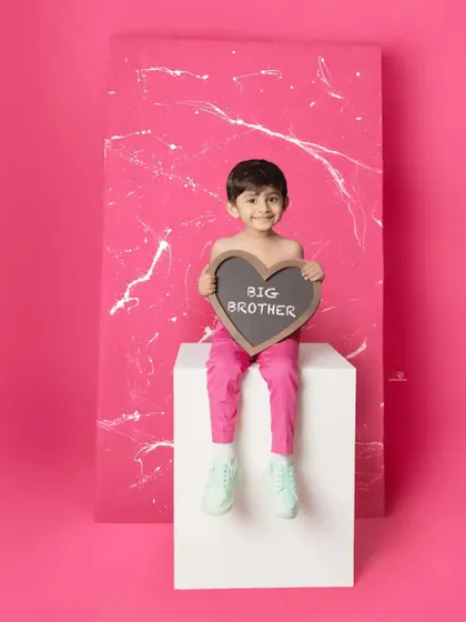 This little guy is ready for his new role as a big brother! Using props like this heart-shaped chalkboard makes for an adorable announcement and a fun memory.