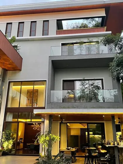 This perspective highlights the home's verticality and the integration of an outdoor bar. The combination of materials and forms creates a contemporary yet timeless architectural statement for this Bangalore residence.