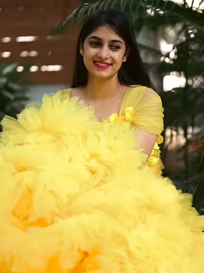 A close-up portrait of a client enjoying her photoshoot in our yellow gown.