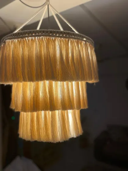 Let there be light! This is a three-tiered boho chandelier I made. The light filters so softly through the macrame fringe, creating a warm and cozy atmosphere.