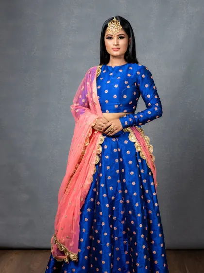 This full-length photo shows how the entire ensemble comes together. The makeup complements the vibrant outfit and statement jewellery, creating a powerful and glamorous look.