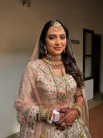Elegant, soft waves for a bride in a beautiful pastel lehenga. This open hairstyle is perfect for a daytime wedding, creating a romantic and ethereal look.