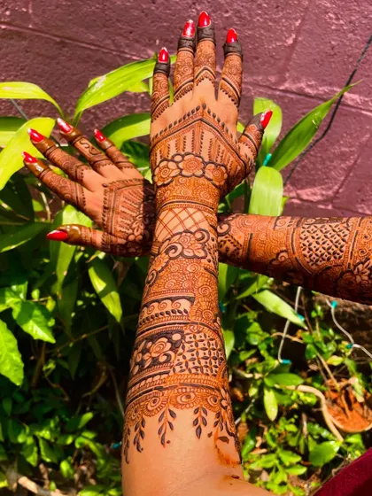 The back of the hands deserves just as much love! This bridal back-hand design features geometric patterns and floral bands that extend up the arm, ensuring beauty from every angle.