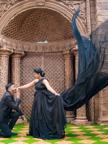 A dramatic pre-wedding photo with a flowing black gown against a grand, carved doorway. This shows how we can create high-fashion, impactful images.