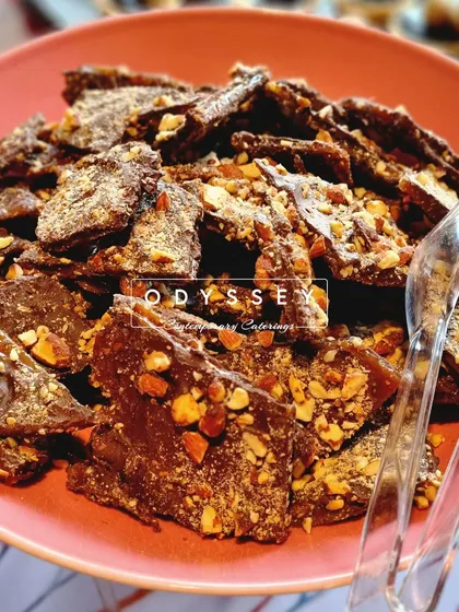 A bowl of our homemade chocolate almond bark. This is a wonderful addition to a dessert table or coffee station, offering a crunchy and nutty sweet bite.