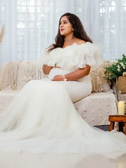 A full-length portrait of the mother-to-be in a stunning white mermaid gown. The bohemian studio setup with pampas grass and dried palms is one of my most popular.