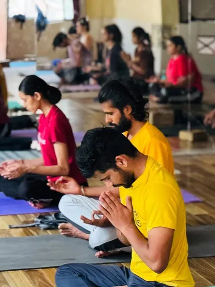 Students in prayer position, offering gratitude at the end of a practice. This gesture of humility and respect is an integral part of the yoga journey.