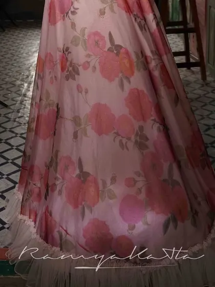 A detail of the printed organza skirt, showing the beautiful floral pattern and the delicate tulle frill at the hem. A design that is both romantic and modern.