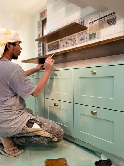 A beautiful pastel green kitchen taking shape. Our carpenter is adding the final touches to these shaker-style cabinets with classic brass knobs, creating a timeless and elegant look.