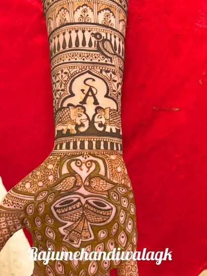 A personalized bridal mehandi featuring the couple's initials 'S' and 'A' within an arch. It also includes elephants, dholkis (drums), and peacocks, blending personal touches with traditional wedding symbols.