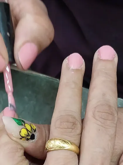 A close-up of the gel polish application, featuring a beautiful sunflower accent nail.