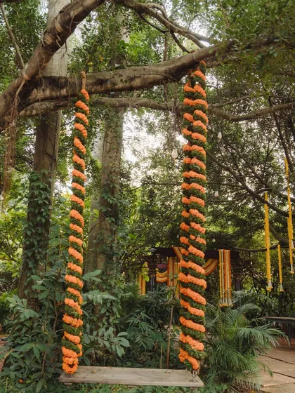 A close-up of the floral swing, decorated with spiraling orange marigolds.
