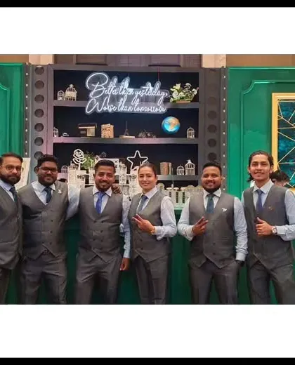 Our team in matching grey vests, ready for a corporate event. The "Globally Workalocal" sign in the background perfectly captures our international reach and local expertise.
