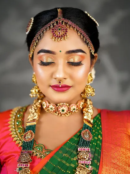 Eyes closed to showcase the stunning sunset-toned eyeshadow. The blend of gold, orange, and pink creates a warm and vibrant look.