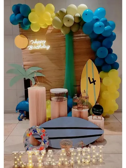 A fun and unique surfing-themed birthday party with surfboard props and a blue and yellow color scheme.