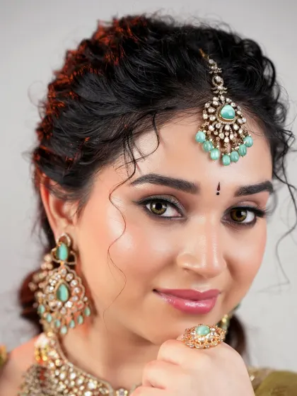 A perfect portrait of modern elegance. The makeup is flawless and radiant, letting the bride's natural beauty shine through while complementing her unique jewelry.
