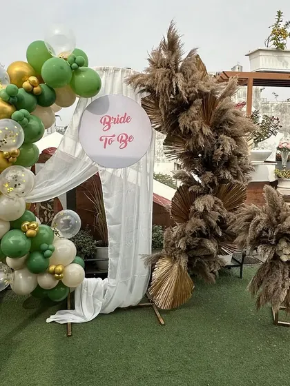 The full view of the chic bridal shower backdrop, showing the combination of the pampas grass arch and the modern balloon garland.