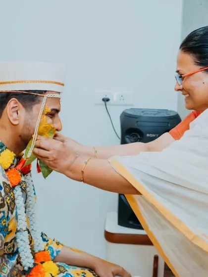 A mother's love captured as she applies Haldi to her son, a tender and significant moment of the ceremony.