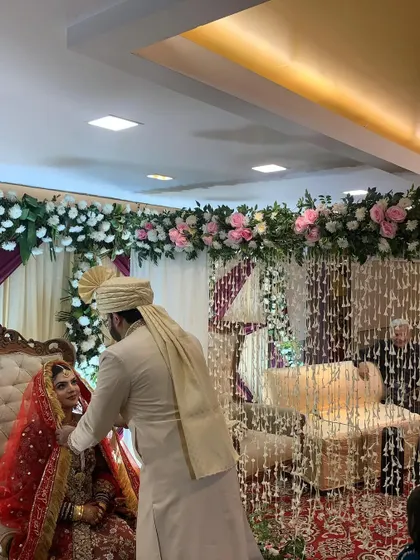 A beautiful moment between the bride and groom during their Nikah ceremony, framed by the elegant floral decor.